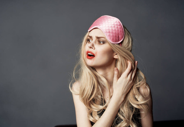 blonde émotionnelle avec un masque de sommeil rose sur sa tête maquillage lumineux Espace de copie - Photo, image