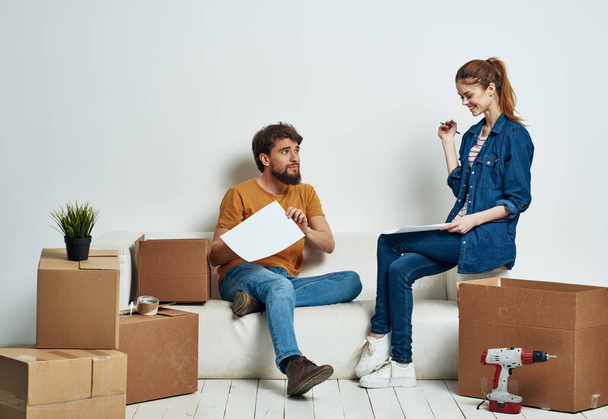 Χαρούμενο νεαρό ζευγάρι σε μια πολυκατοικία με πράγματα να κινούνται  - Φωτογραφία, εικόνα