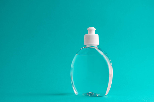 Bottle of hand sanitizer or antiseptic gel on aquamarine background - Photo, Image