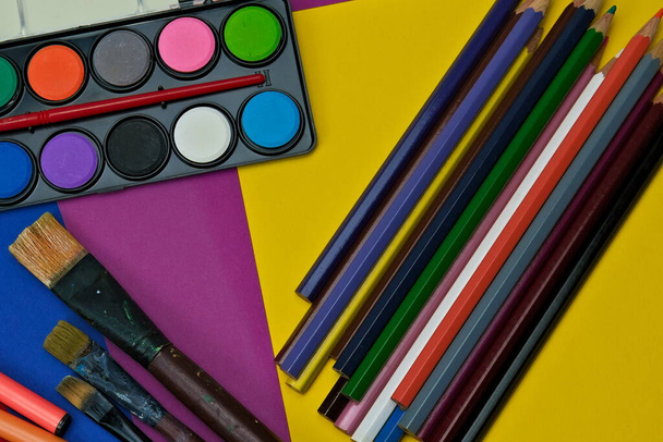 Art supplies for creative minds, paintbrushes, watercolors, pencils and colored cardboard.  - Photo, Image