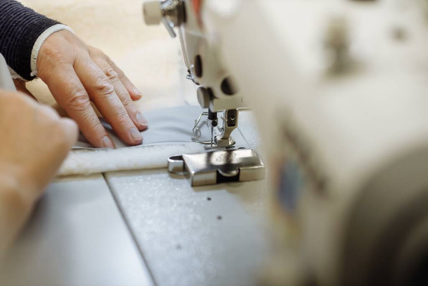 Швейная машинка нацарапала ткань. пошив на заводе. - Фото, изображение