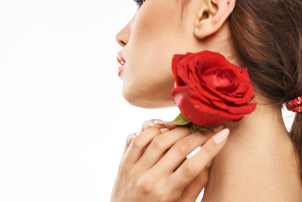 Portrét ženy s červenou růží nahá ramena make-up na tváři brunetky - Fotografie, Obrázek