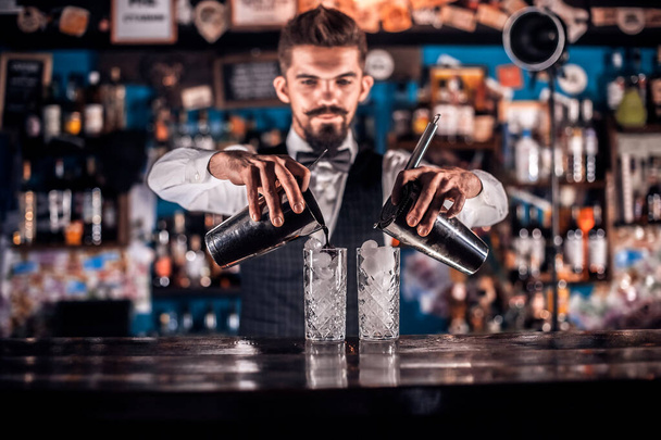 Joven barman demuestra el proceso de hacer un cóctel en el pub - Foto, imagen
