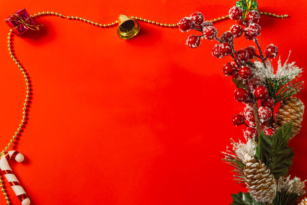 κόκκινο χριστουγεννιάτικο φόντο διακόσμηση κουδουνιών κουτί δώρου, κόκκινο και χρυσό στεφάνι, μπάλες Χριστούγεννα και λουλούδια - Φωτογραφία, εικόνα