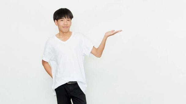 Retrato de un atractivo joven asiático en camiseta blanca casual haciendo gesto de mano abierta aislado sobre fondo blanco - Foto, imagen
