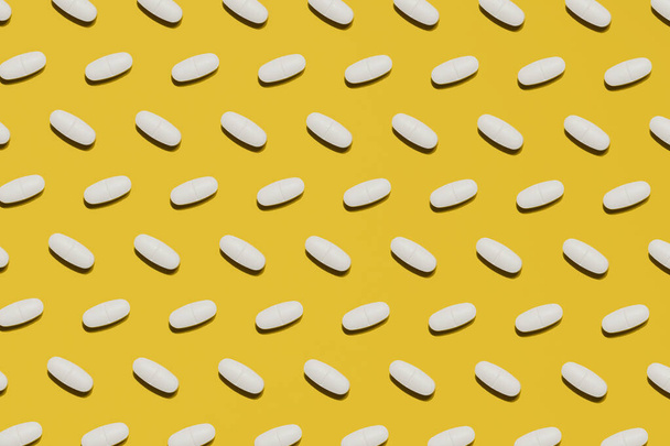 Medicine pills and tablets on yellow background - Fotoğraf, Görsel
