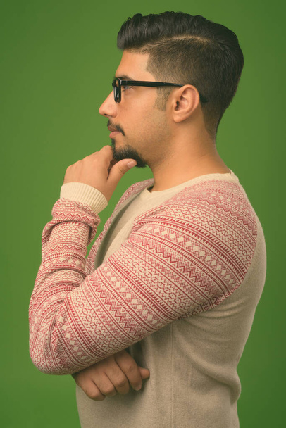Young bearded Iranian man against green background - Valokuva, kuva