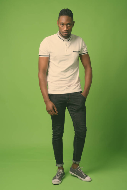 Jonge knappe Afrikaanse man uit Kenia tegen groene achtergrond - Foto, afbeelding