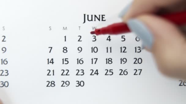 赤いマーカーでカレンダー日付の女性の手の円の日。ビジネスの基本壁カレンダープランナーと主催者。6月3日 - 映像、動画