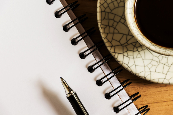 рабочий стол с бумагой, ручкой и чашкой растворимого кофе
 - Фото, изображение