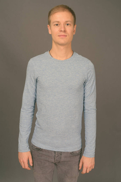 Portrait of young handsome man against gray background - Fotografie, Obrázek