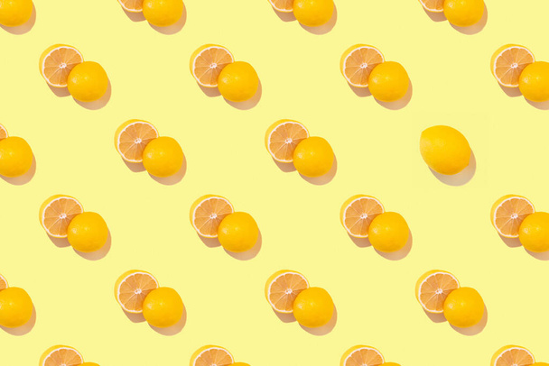 Nahtloses, regelmäßiges Muster mit frischen Zitronen auf gelbem Hintergrund. Hartes Licht. Minimale Sommerzusammensetzung. - Foto, Bild