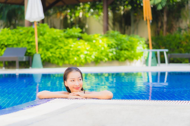 Portrait belle jeune femme asiatique sourire détendre loisirs autour de la piscine extérieure dans la station hôtelière - Photo, image
