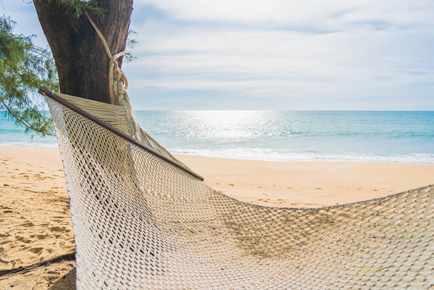Lege hangmat op tropisch strand zee oceaan voor ontspanning ontspannen in vakantie reizen - Foto, afbeelding