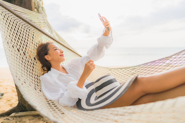 Portrait beautiful young asian woman relax on hammock around beach sea ocean for leisure in vacation - Foto, Bild