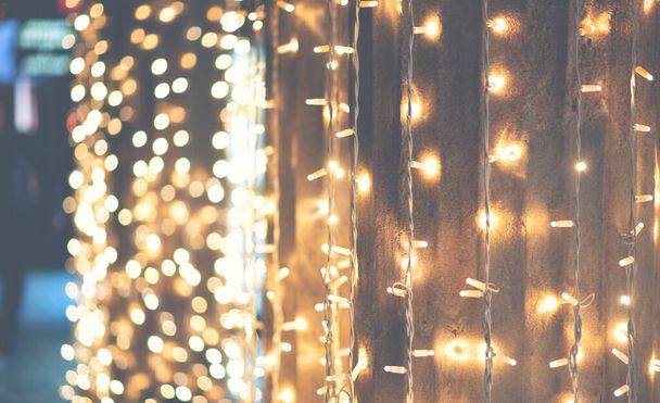Gold glitter vintage lights background. blurred image of festive illumination. Decorated lights Christmas street on blurred background. - Photo, image