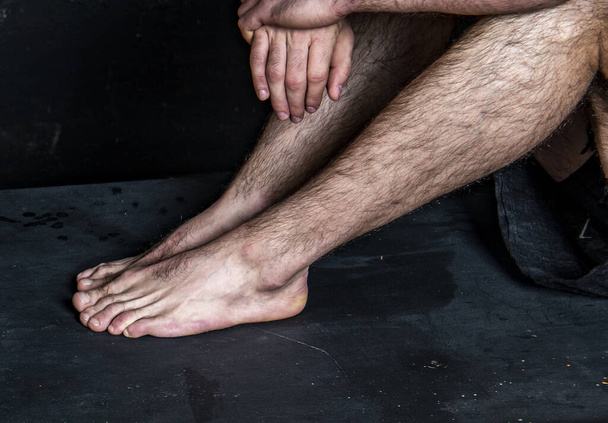 黒い背景をした穏やかな位置にいる男性の裸の足は - 写真・画像