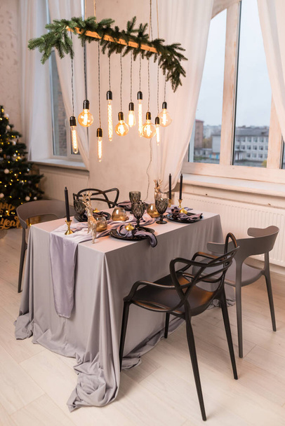 Boční pohled na slavnostní posezení u vánočního stolku s prázdnými sklenicemi na víno a černým talířem. Koncept Vánoc a Nový rok - Fotografie, Obrázek