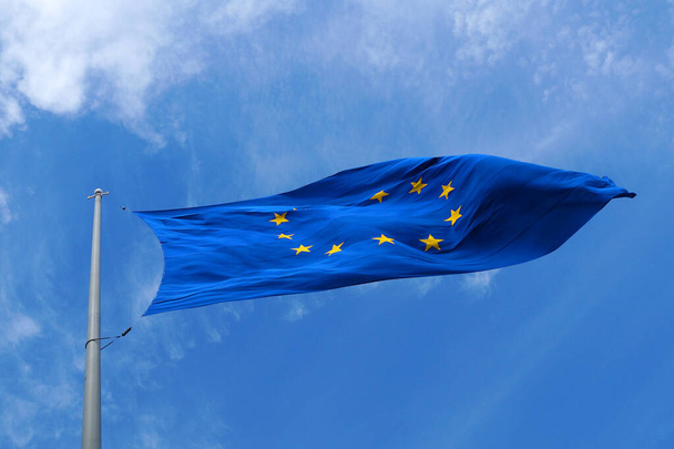 EU-vlag wapperend in de wind tegen de lucht close-up - Foto, afbeelding