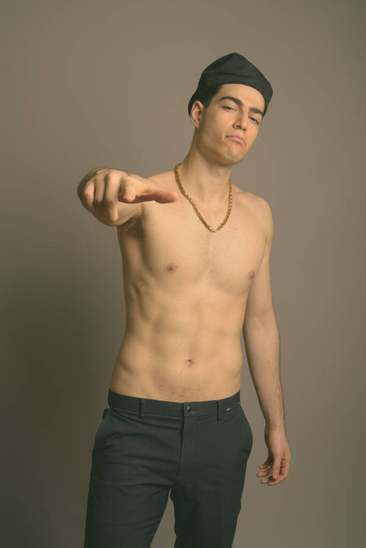 Young handsome man shirtless against gray background - Foto, Imagen