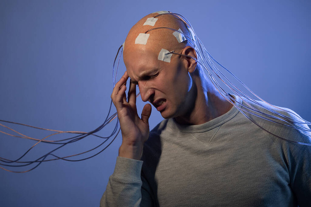 man with a bald head with wires connected. Fear and anxiety. Examination of the brain, - Foto, Bild