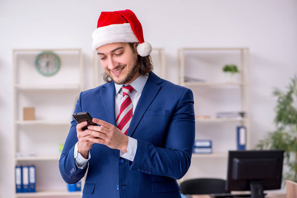 Young male employee working in the office at Christmas Eve - Photo, Image