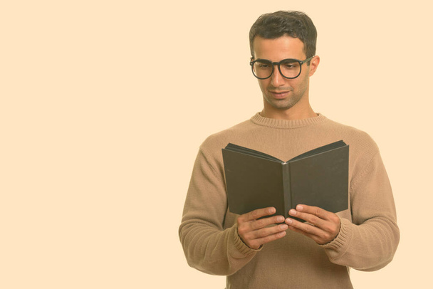 Jovem homem iraniano feliz sorrindo e lendo livro - Foto, Imagem