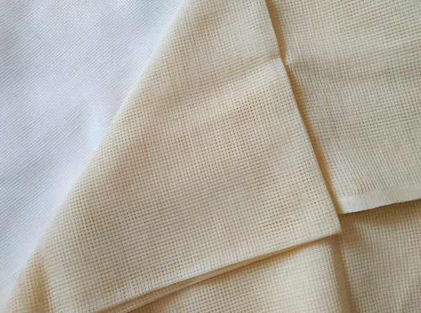 Бежевый и молочно-белый сложенный холст. Текстура ткани  - Фото, изображение