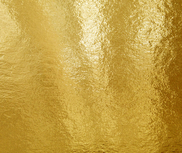 Zlatá fólie textura pozadí se zvýrazněním a nerovným povrchem - Fotografie, Obrázek