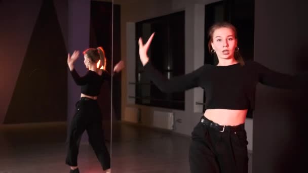 Piękna kobieta gogo tancerka tańczy nowoczesną młodą choreografię w studio tańca przed dużym lustrem.  - Materiał filmowy, wideo