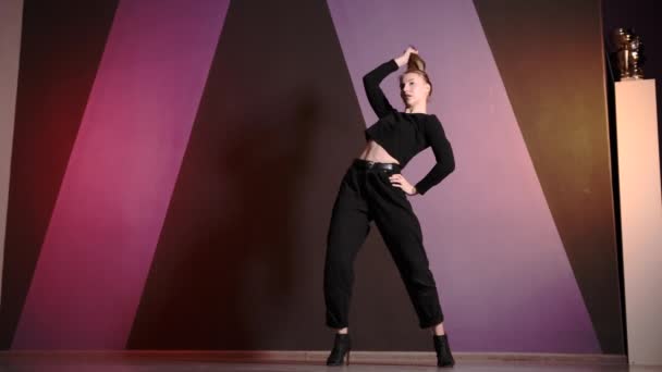 Κομψή νεαρή γυναίκα με ψηλά τακούνια χορεύει μοντέρνα πλαστική χορογραφία σε σχολή χορού - Πλάνα, βίντεο