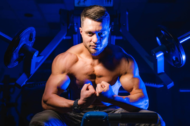 Brutal strong athletic men pumping up muscles. Doing workout on sport equipment - muscular bodybuilder doing exercises in gym with naked torso. Fitness and bodybuilding concept. - Foto, Imagem