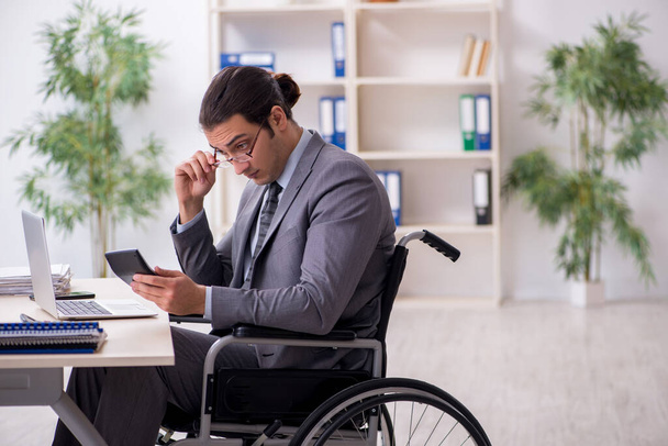 Young male employee in wheel-chair - Foto, afbeelding