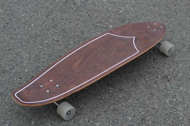 planche à roulettes en bois sur fond d'asphalte - Photo, image