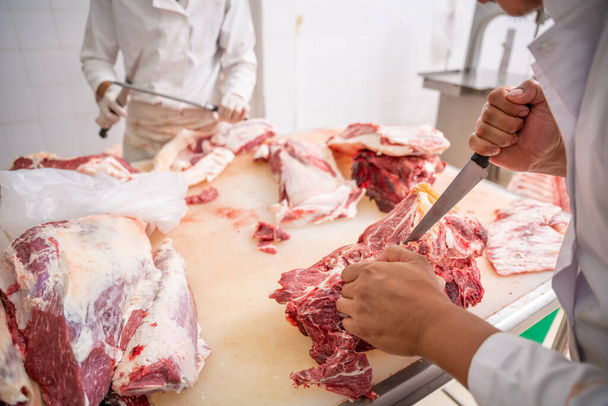 A közeli hentes késsel elválasztja a csontot a hústól a vágóhídon, a Wagyu marhahúsban.. - Fotó, kép