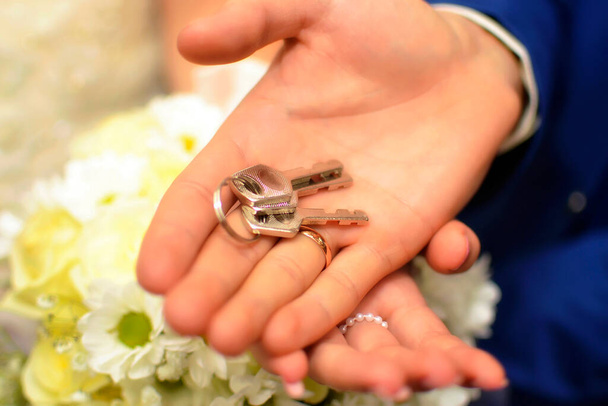 kulcsok a friss házasok kezében esküvői ajándék. - Fotó, kép