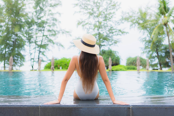 Портрет красивая молодая азиатская женщина расслабиться улыбка отдыха вокруг открытый бассейн в отеле курорт почти морской пляж - Фото, изображение