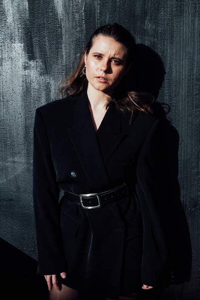 Portrait of a beautiful fashionable brunette woman in a black business jacket - Foto, Imagen