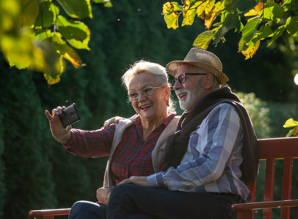 Seniorenpaar nutzt Mobiltelefon für Videoanrufe mit Verwandten während Pandemie- und Quarantäne-Zeit - Foto, Bild