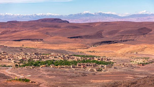 Fotografia de ângulo largo diurno de uma cidade e as Montanhas Atlas no fundo, Marrocos. - Foto, Imagem