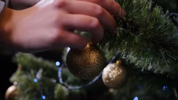 Kerstmis en gelukkig Nieuwjaar symbolen. Vrouw versieren kerstboom met ballen en speelgoed, close-up, Wintertijd feestdagen feestelijke seizoen voorbereiding, Nieuwjaar viering. 4 k video - Video