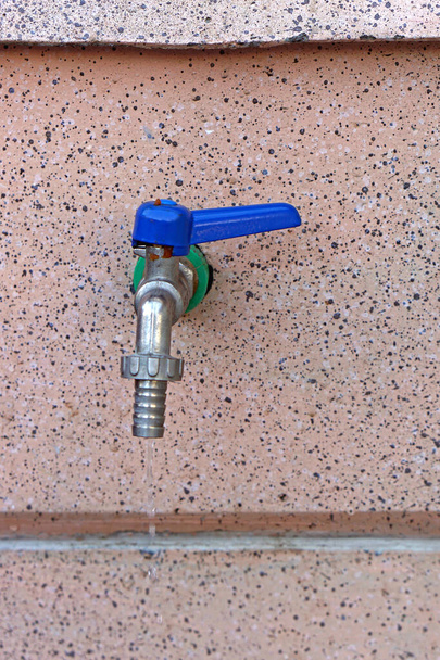 Водный кран с синей ручкой и креплением шланга
 - Фото, изображение