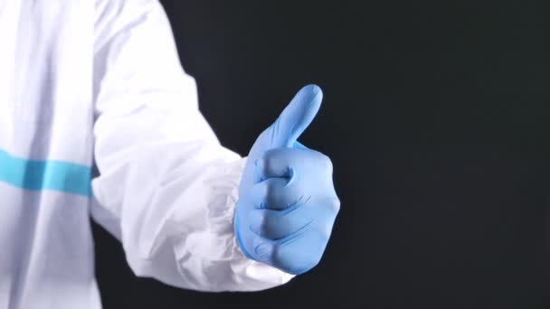 Detailní záběr na ruku odtahovky v lékařských rukavicích ukazující palec nahoru. - Záběry, video