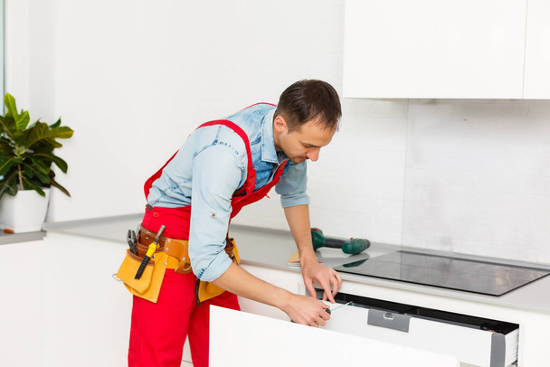 Handyman fijación de gabinete de la cocina con destornillador - Foto, Imagen