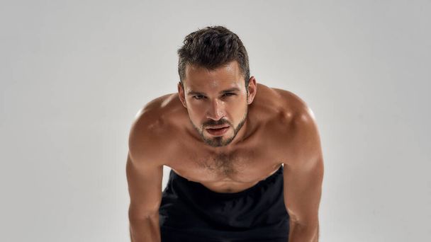 Young shirtless caucasian muscle man standing bent over - Zdjęcie, obraz