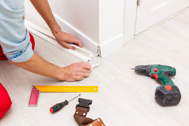 Man putting new skirting board in house - Foto, imagen