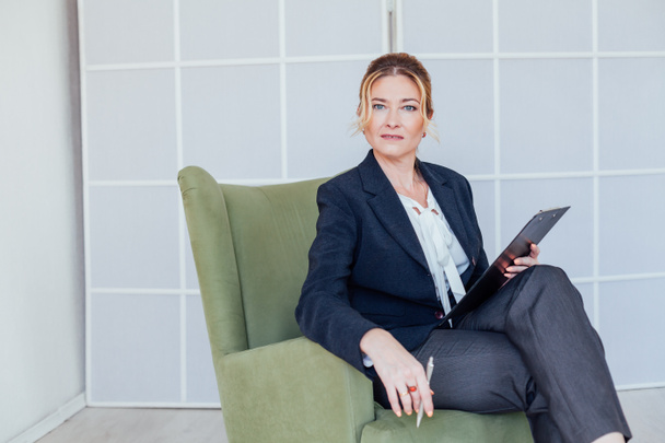 όμορφη γυναίκα με επιχειρηματικό κοστούμι στη δουλειά στο γραφείο σε μια καρέκλα ψυχολόγος - Φωτογραφία, εικόνα