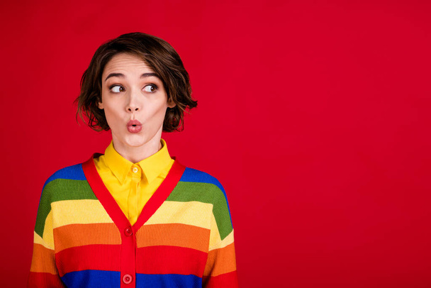 Photo of beautiful funny curious lesbian lady good mood look side empty space wondered open mouth wear colorful rainbow jumper cardigan isolated bright red color background - Valokuva, kuva
