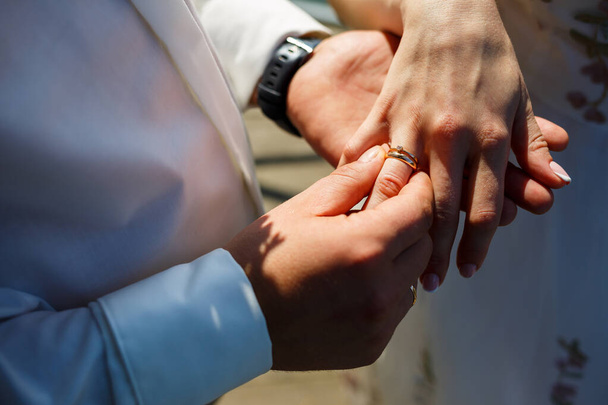 anillos de oro en las manos de los recién casados - Foto, imagen
