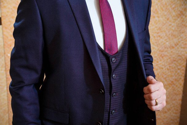 A man puts on a men's suit on the day of the wedding - Фото, изображение